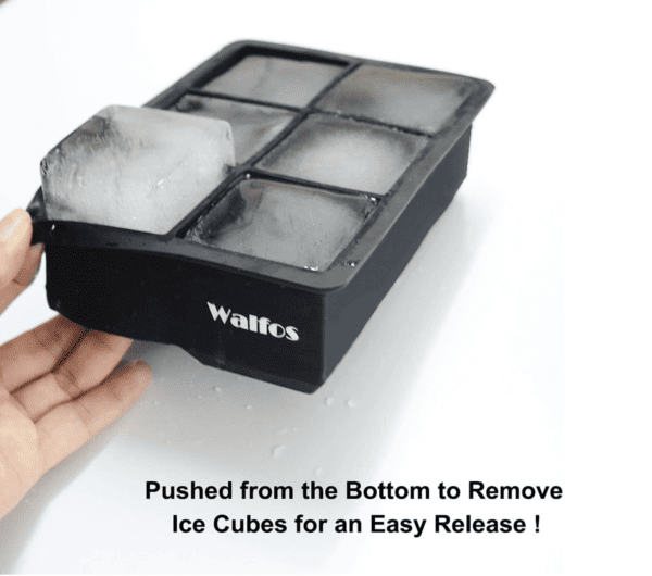 A hand is holding an ice cube tray with six cubes.